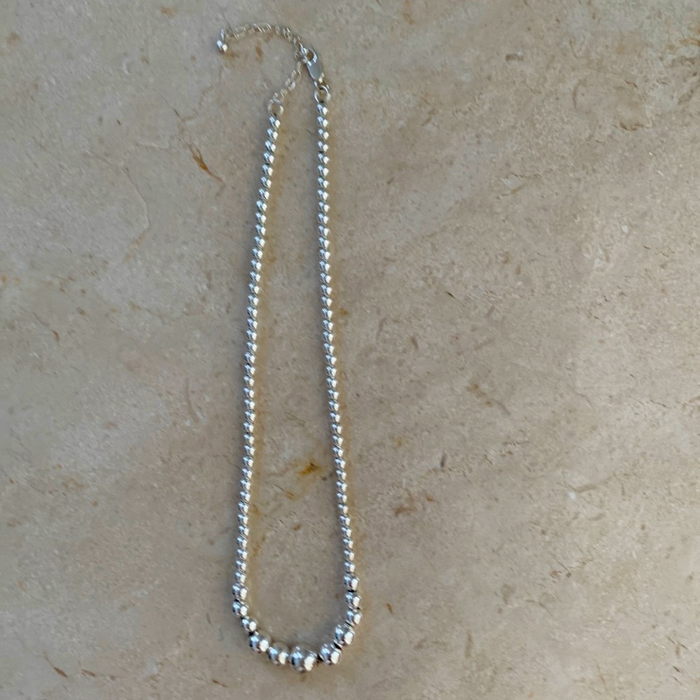 Silver graduated ball necklace.